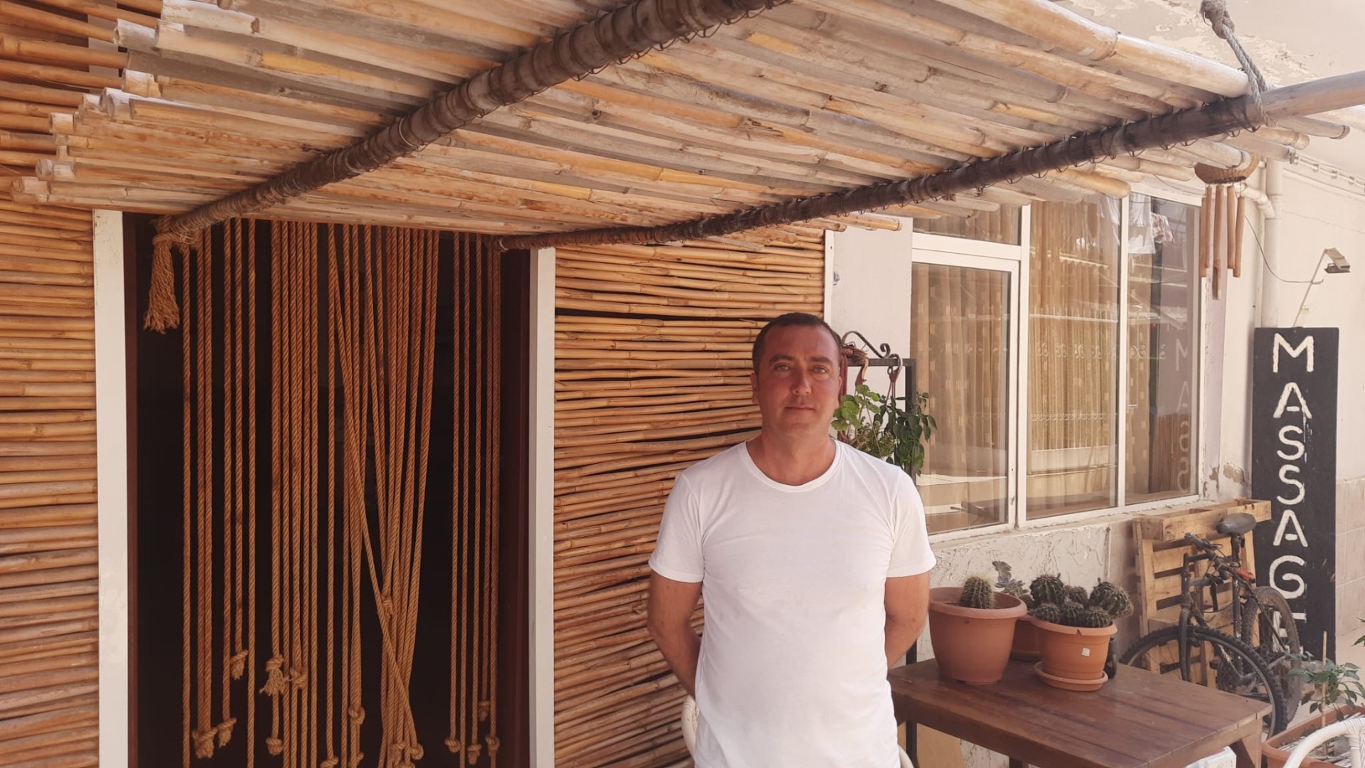 Hamamın kurucusu, bambu kaplı girişin önünde